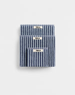 Three blue and white striped TEKLA towels on a light gray background