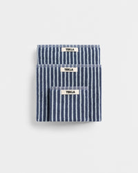 Three blue and white striped TEKLA towels on a light gray background
