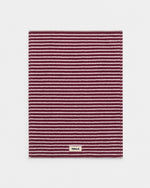 Striped rug with a brand label on a light gray background