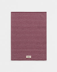 Striped rug with a brand label on a light gray background