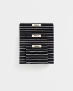 Black and white striped blanket with 'Tekla' label on a white background