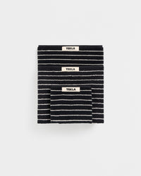 Black and white striped blanket with 'Tekla' label on a white background