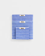 Three blue striped towels with 'Tekla' labels on a white background