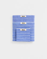 Three blue striped towels with 'Tekla' labels on a white background
