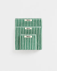Three folded green and white striped cotton bath towels stacked vertically on a light gray background, each with a small white label reading TEKLA.