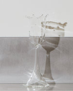 Clear glass on a reflective surface with a neutral background