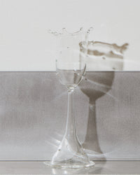 Clear glass on a reflective surface with a neutral background
