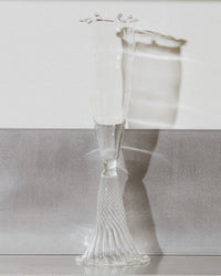 Clear glass vase with textured base on a reflective surface
