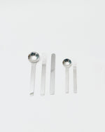 Set of silver cutlery including spoons and forks on a white background