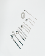 Set of silver kitchen utensils on a light gray background