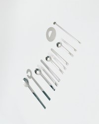 Set of silver kitchen utensils on a light gray background