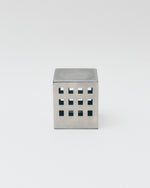 Metallic cube with square cutouts on a white background