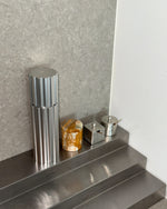Metallic canister on a metallic surface with a neutral background
