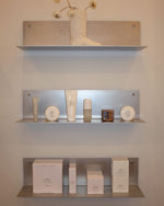 Shelves with skincare products against a neutral wall