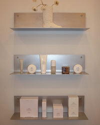 Shelves with skincare products against a neutral wall