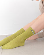 Person wearing green socks on a light background