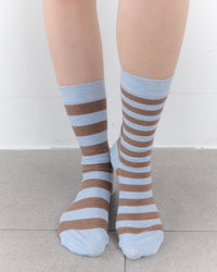 Striped socks worn by a person on a light background