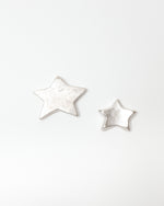 Star-shaped silver objects on a white background