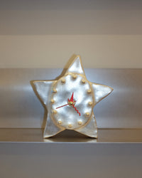 Star-shaped clock with a glowing interior on a plain background