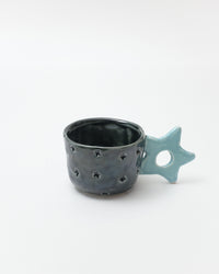 Ceramic cup with star-shaped handle on a white background