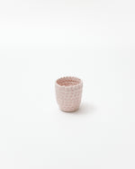 Pink textured ceramic cup on a white background