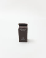 Black package of black rice milk on a white background