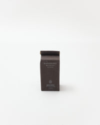 Black package of black rice milk on a white background