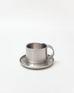 Stainless steel cup and saucer on a white background