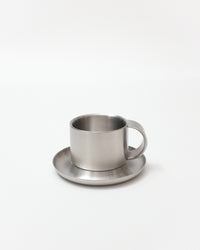 Stainless steel cup and saucer on a white background