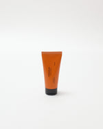 Orange tube of cream on a white background