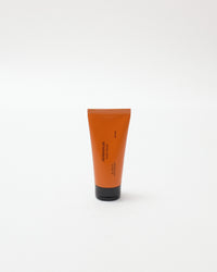 Orange tube of cream on a white background
