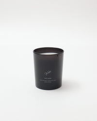 Black candle in a cylindrical container on a white background