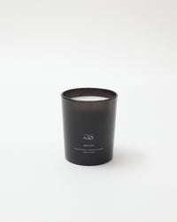 Black candle with a visible brand logo on a white background