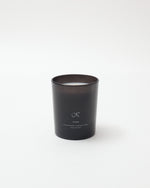 Black candle with a brand logo on a white background