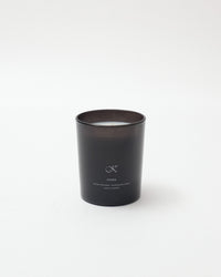 Black candle with a brand logo on a white background