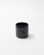 Black textured ceramic cup on a white background