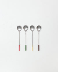 Four spoons with colorful handles on a white background