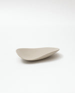 Wavy beige ceramic plate on a white background