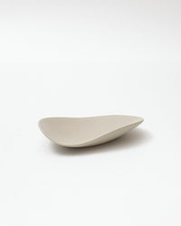 Wavy beige ceramic plate on a white background