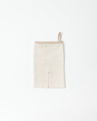 Beige body scrub mitt on a white background