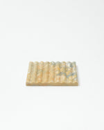 Rectangular soap dish with textured surface on a white background