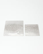 Two rectangular silver plates on a white background