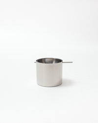 Small stainless steel pot with a handle on a white background