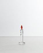 Silver candle-shaped object with a red top on a white background