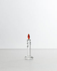Silver candle-shaped object with a red top on a white background