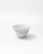 Ceramic bowl with horizontal blue stripes on a white background