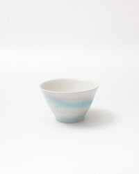Ceramic bowl with horizontal blue stripes on a white background