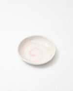 Small white ceramic bowl with a textured surface on a light gray background