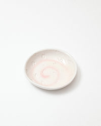 Small white ceramic bowl with a textured surface on a light gray background