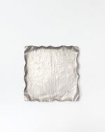 Silver textured square dish on a white background
